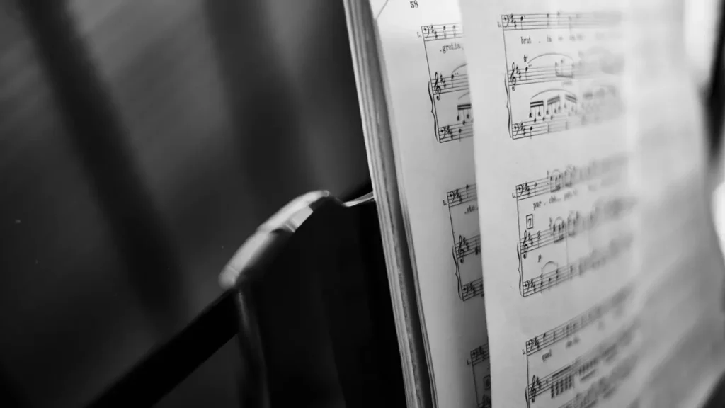 A black and white photo of a music score. Themes of looped tracks.