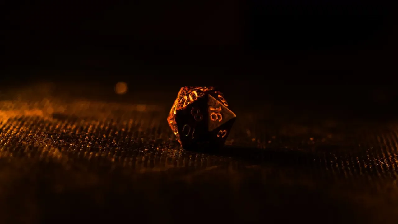 A close up of a D20 dice on a table.
