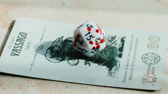 a-white-and-red-dice-sitting-on-top-of-a-piece-of-paper A white and red dice sitting on top of a piece of paper.