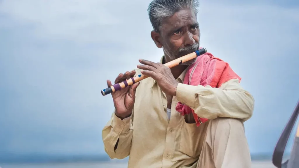 Man playing flute outdoor.