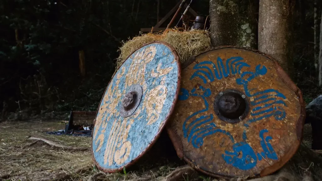A pile of hay sitting next to a forest filled with trees. Themes of 2024 Dungeon Master's Guide.