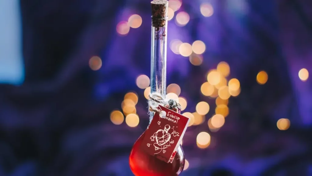 A red potion vial hangs with a decorative tag. Magical red potion. Love potion. Witch's potion. Alchemy. Magic bottle. Witchcraft. Themes of 2024 Dungeon Master's Guide.