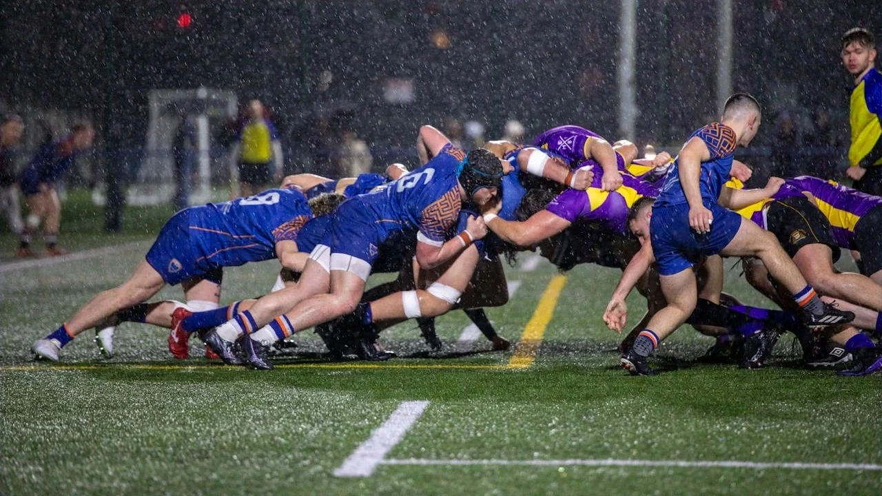 A game of rugby during a scrum in the rain.