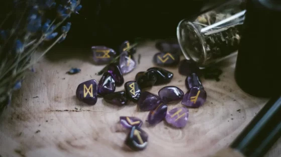silver-can-on-brown-wooden-table Purple stones with runes inscribed. Themes of the raiders principle.