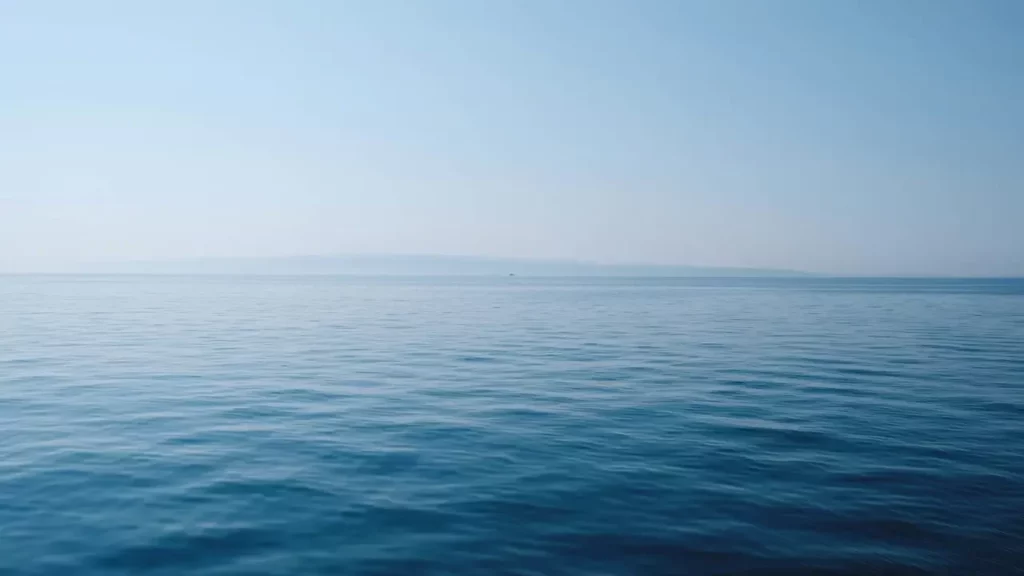 Body of water under blue and white sky at daytime. Themes of Season of Ghosts soundtrack.