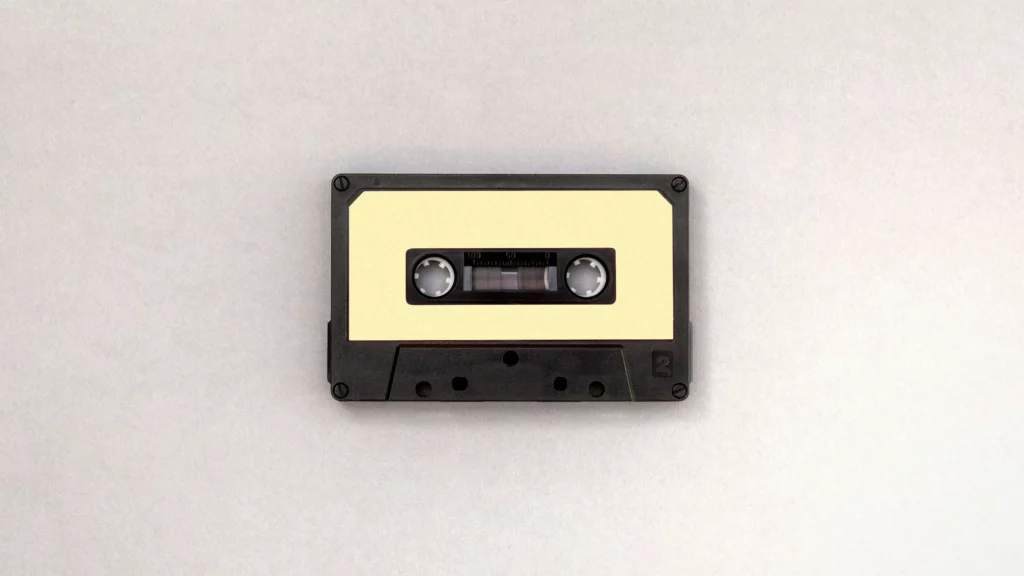 Photo of black and brown cassette tape. Themes to find the audio.