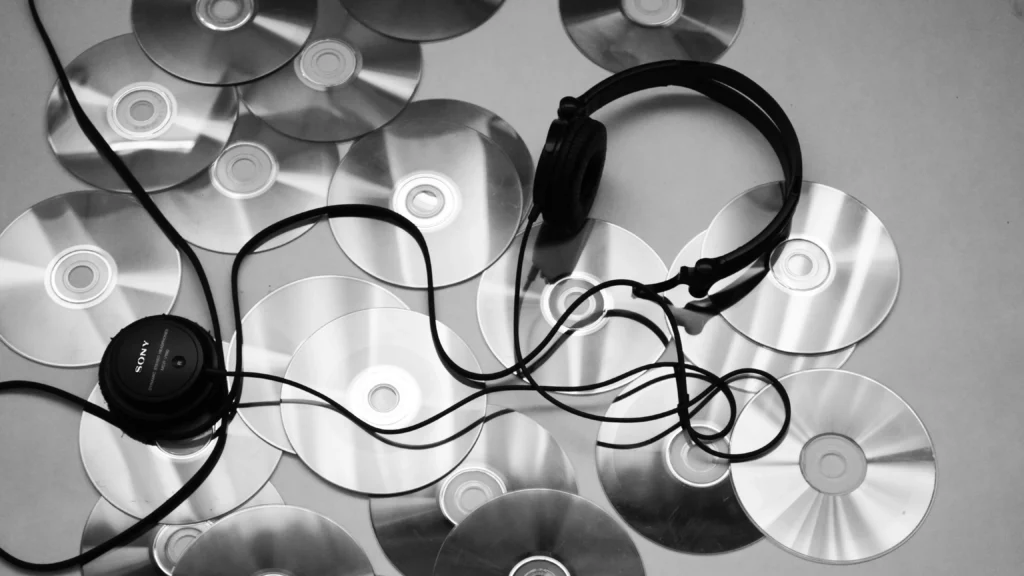 Black corded headphones on white surface. Themes of every audio.