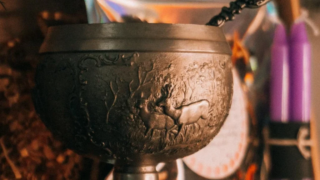 A photo of a large goblet or chalice with a stag and forest scene engraved on it.